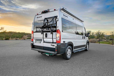 Silver Thor Scope RV rental parked at sunset, featuring a bike rack and awning. Perfect for road trips and outdoor adventures.