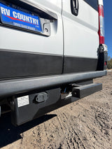 Rear of an **rv rental** camper van, revealing essential black and grey holding tanks, trailer hitch, and electrical connector for travel.