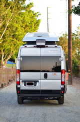 Rear view of a silver Winnebago Sol camper van (RV), parked on gravel. Great for your next rv rental.