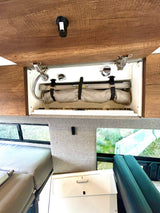 RV rental: Overhead compartment reveals flexible shower & secure roll-up storage. Features comfy bed, window view.