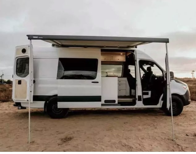  perfect for mobile living.|White camper van (rv rental) with an extended awning and open doors — photo 3