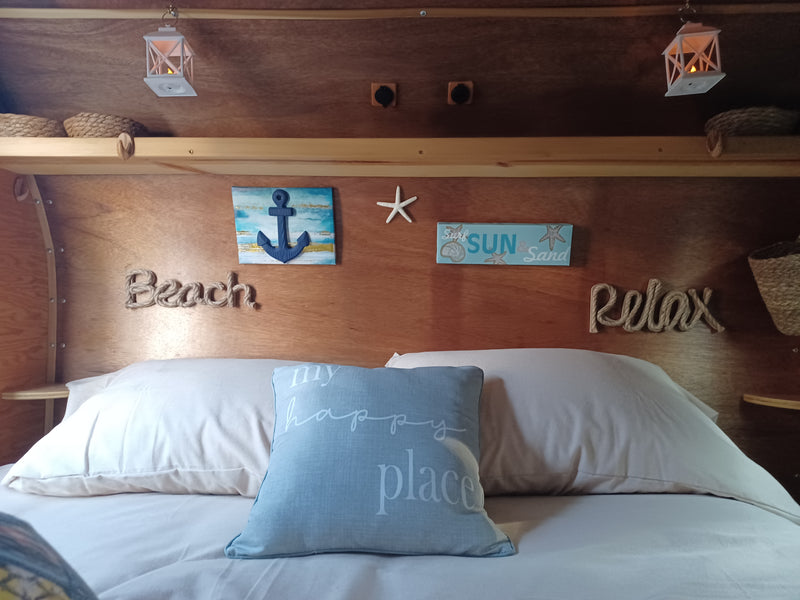 Relax in this RV rental! Cozy bed area with beach-themed decor: anchor, rope words, lanterns, and a "my happy place" pillow. — photo 10