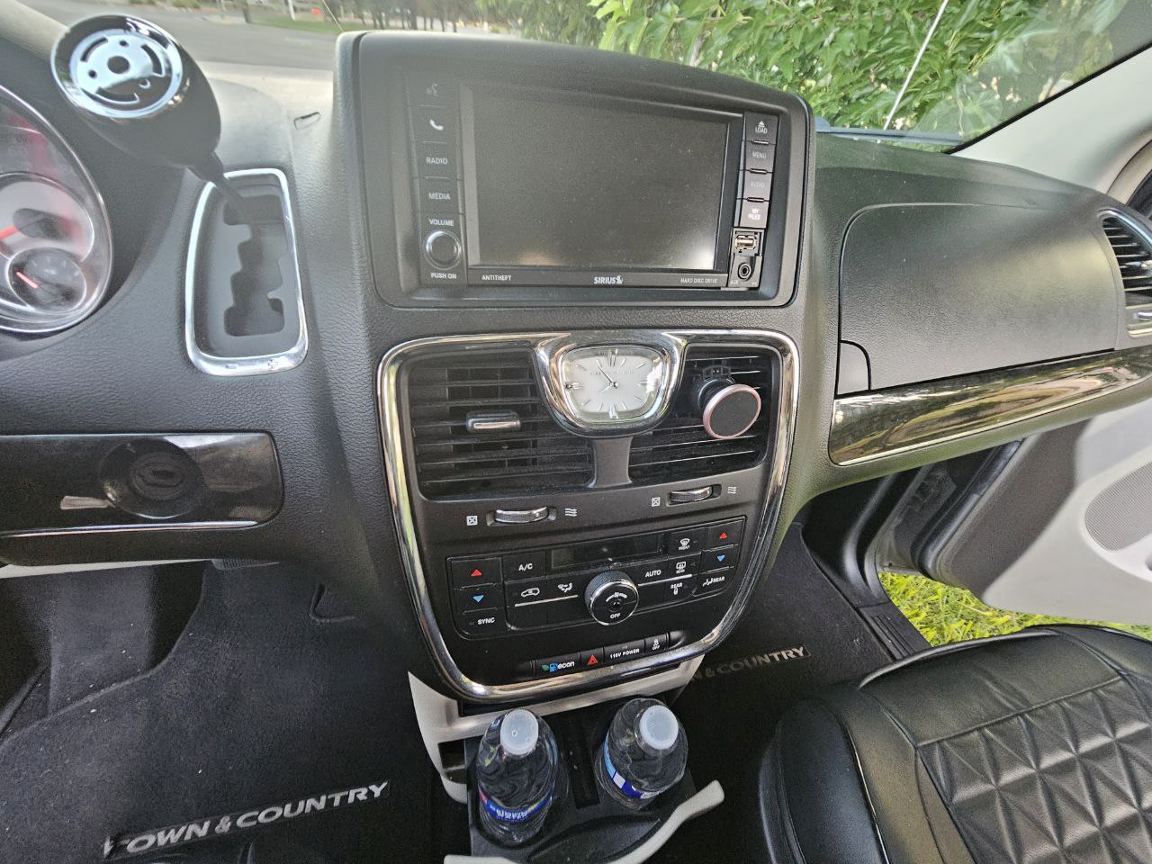 RV rental interior: close-up of a Chrysler Town & Country dashboard, infotainment, and controls. Shows comfort and features for travel.