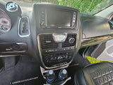 RV rental interior: close-up of a Chrysler Town & Country dashboard, infotainment, and controls. Shows comfort and features for travel.