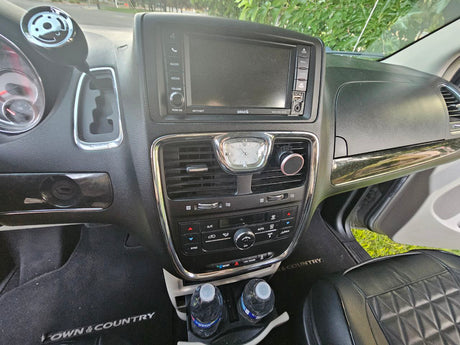 RV rental interior: close-up of a Chrysler Town & Country dashboard, infotainment, and controls. Shows comfort and features for travel.