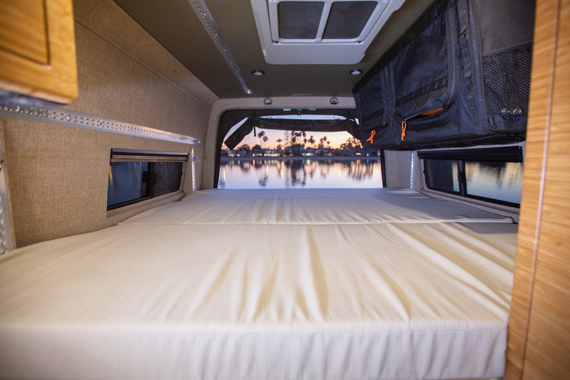  and amazing desert sunset views through the open rear doors.|Spacious camper van interior shows a convertible bed — photo 9