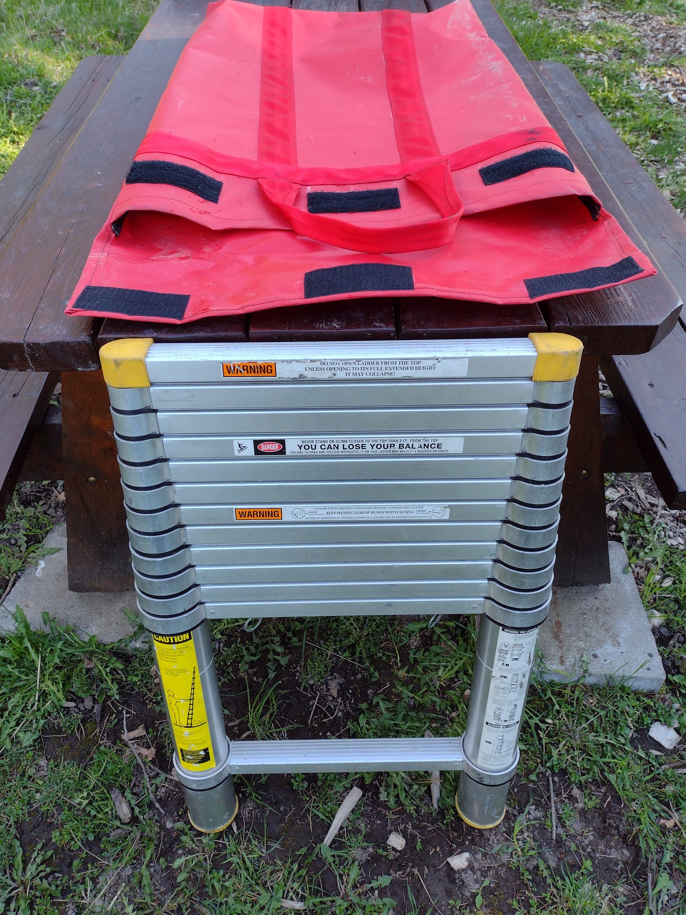 Compact telescoping ladder & carry bag, a practical accessory for RV rental trips. Visible safety warnings highlight safe use.