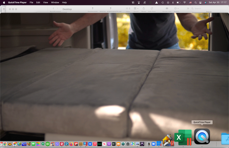 macOS screenshot: QuickTime Player shows an RV rental interior, featuring a gray, foldable bed or seating area, with a person's arms.
