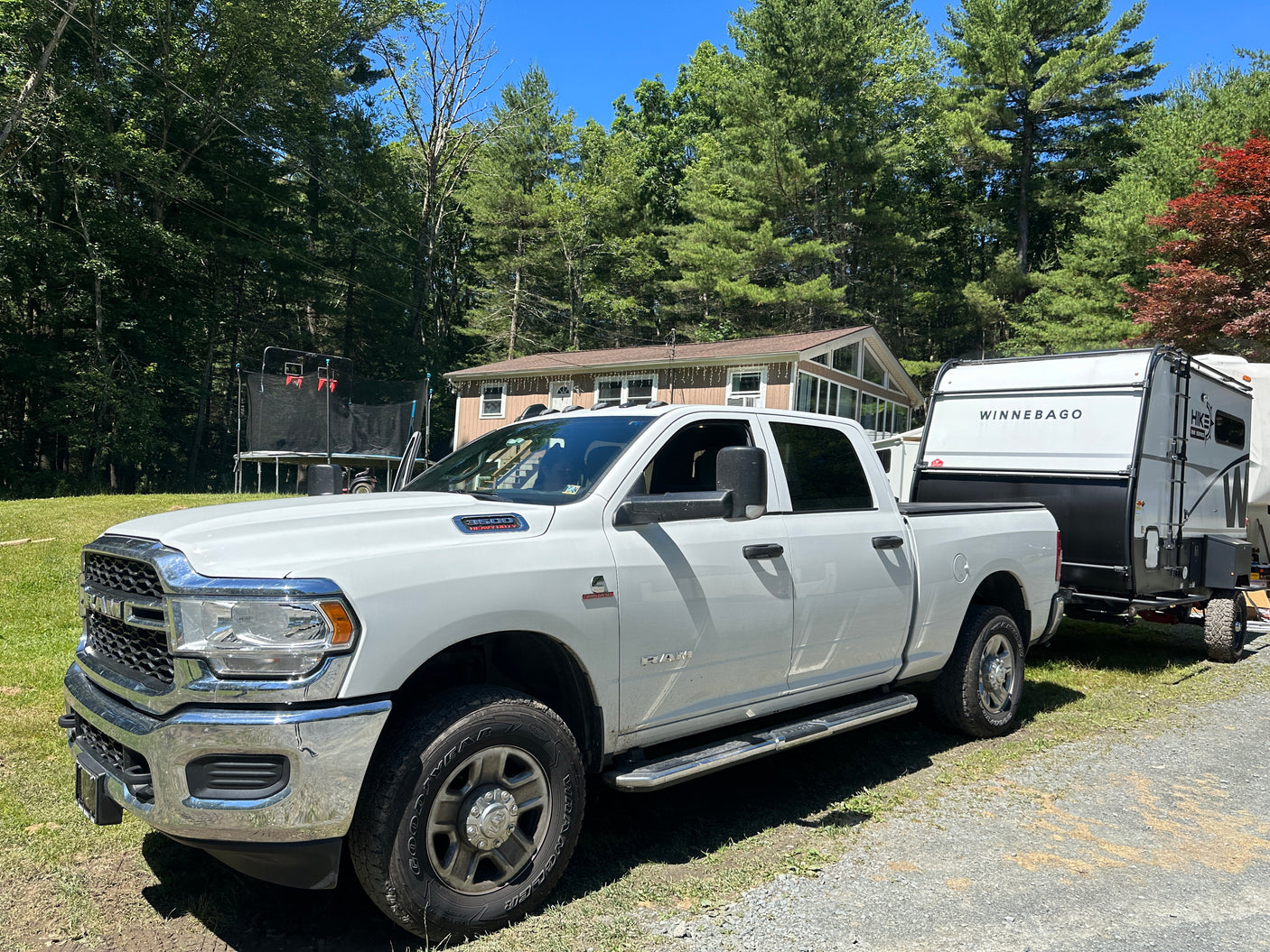 White Ram truck towing Winnebago RV trailer on a sunny day. Perfect setup for an RV rental adventure!