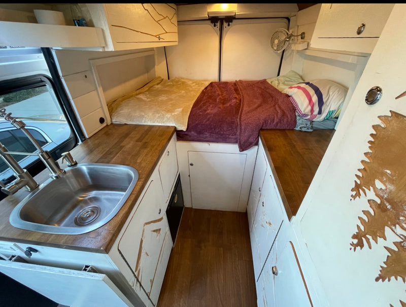  parked by tall pines under a blue sky. Ready for outdoor adventure!|Front cabin of an rv rental — photo 4