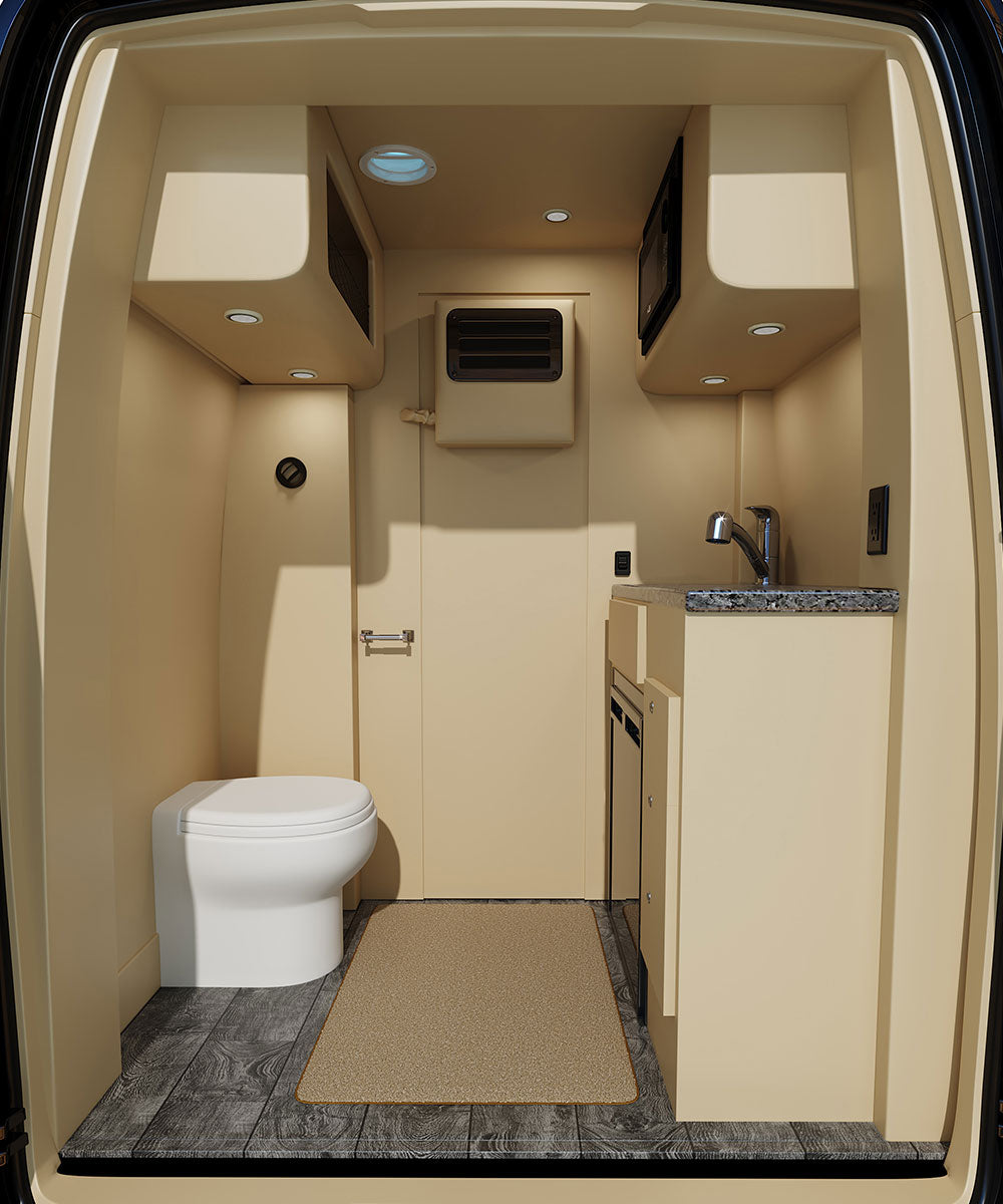 RV rental interior: beige kitchenette with sink, microwave, and toilet area, featuring wood-look flooring. Perfect for compact travel.