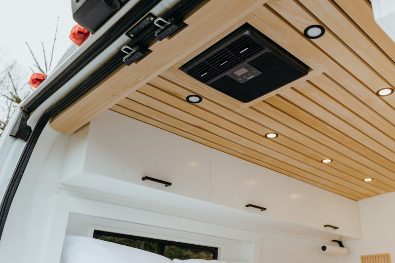 Step inside this rv rental's cozy interior, featuring a stylish wood-slat ceiling, integrated AC, and crisp white overhead cabinets. — photo 12