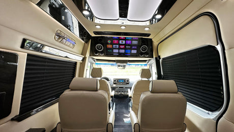 Inside a luxurious **rv rental**: cream leather seats, a large entertainment screen with apps, and sleek interior design for premium travel.
