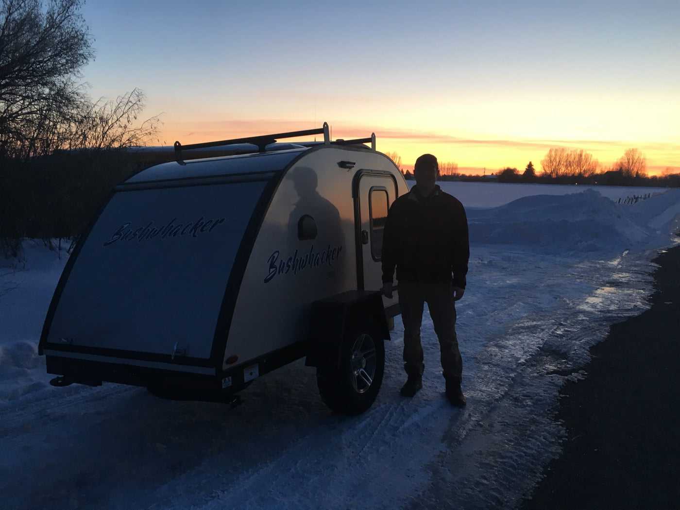 Bushwhacker teardrop RV rental, ready for winter adventures with a man at snowy sunset. — photo 9