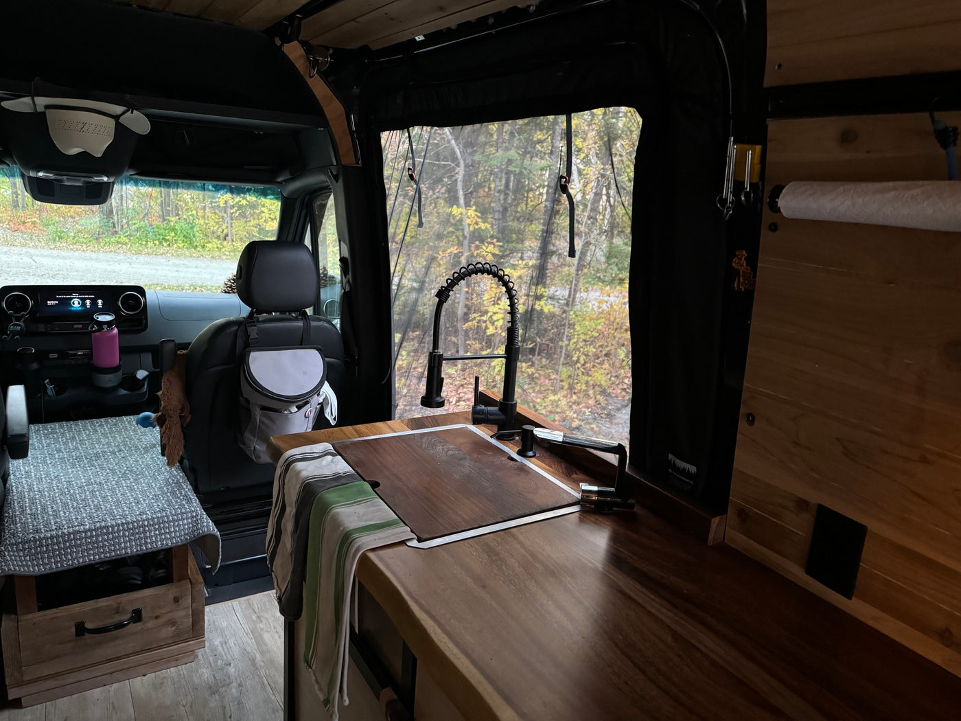  and an Igloo cooler stored underneath.|Inside an rv rental: dark Scheel-Mann front seats with armrests — photo 10