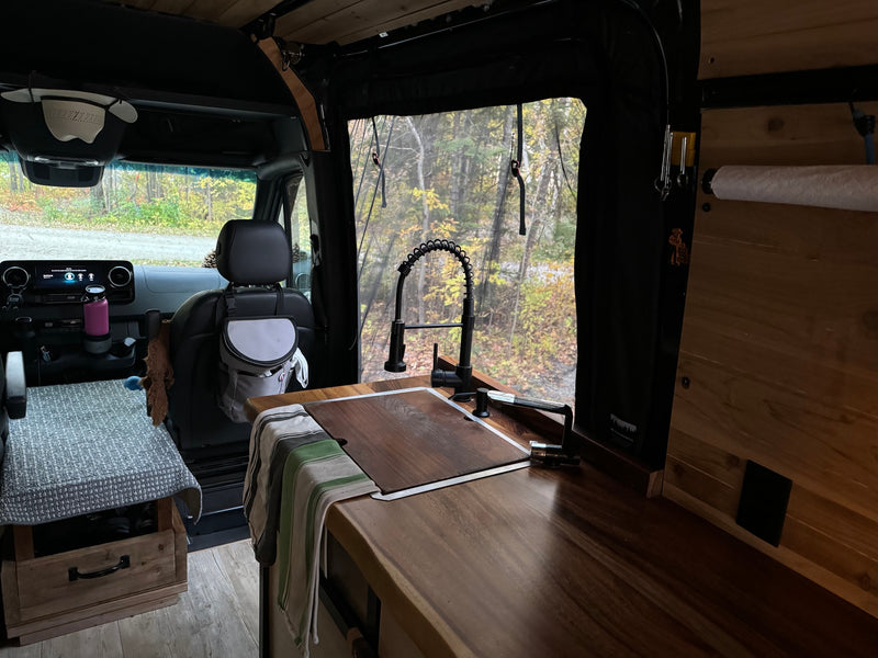  and an Igloo cooler stored underneath.|Inside an rv rental: dark Scheel-Mann front seats with armrests — photo 10