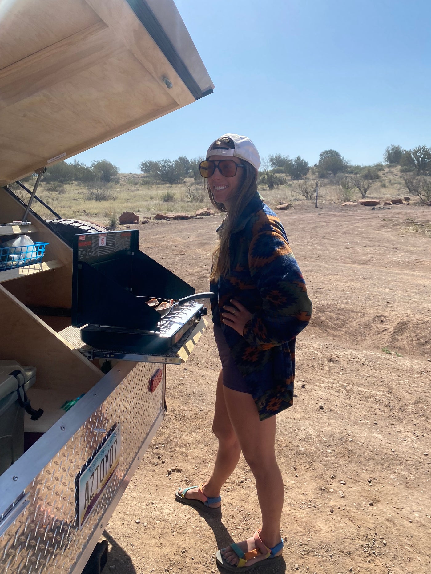 Happy camper: Woman smiles while cooking on a portable stove from her rv rental teardrop trailer. — photo 13