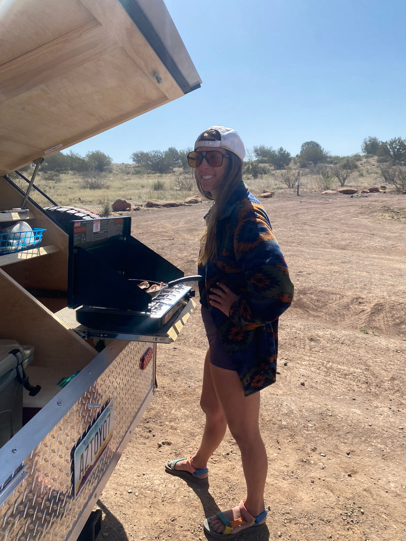 Happy camper: Woman smiles while cooking on a portable stove from her rv rental teardrop trailer. — photo 13