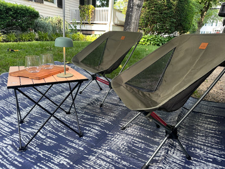 A cozy outdoor setup with portable chairs, table, and mat for your RV rental. Perfect for unwinding in nature.