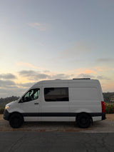 White Mercedes Sprinter RV rental campervan parked at golden hour. Ideal for travel & van life adventures.