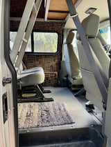 Interior of an rv rental van featuring comfortable grey seating, a pixel wall, and durable flooring.