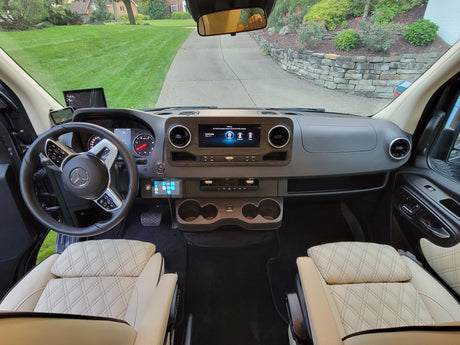 Spacious Mercedes-Benz rv rental cockpit, featuring a modern dashboard, steering wheel, and comfortable quilted seats.