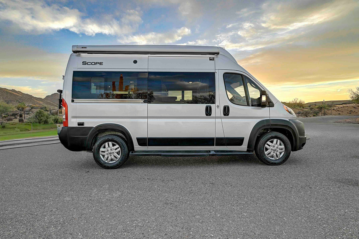 Silver Scope camper van rv rental, parked outdoors for adventure under a cloudy sky.