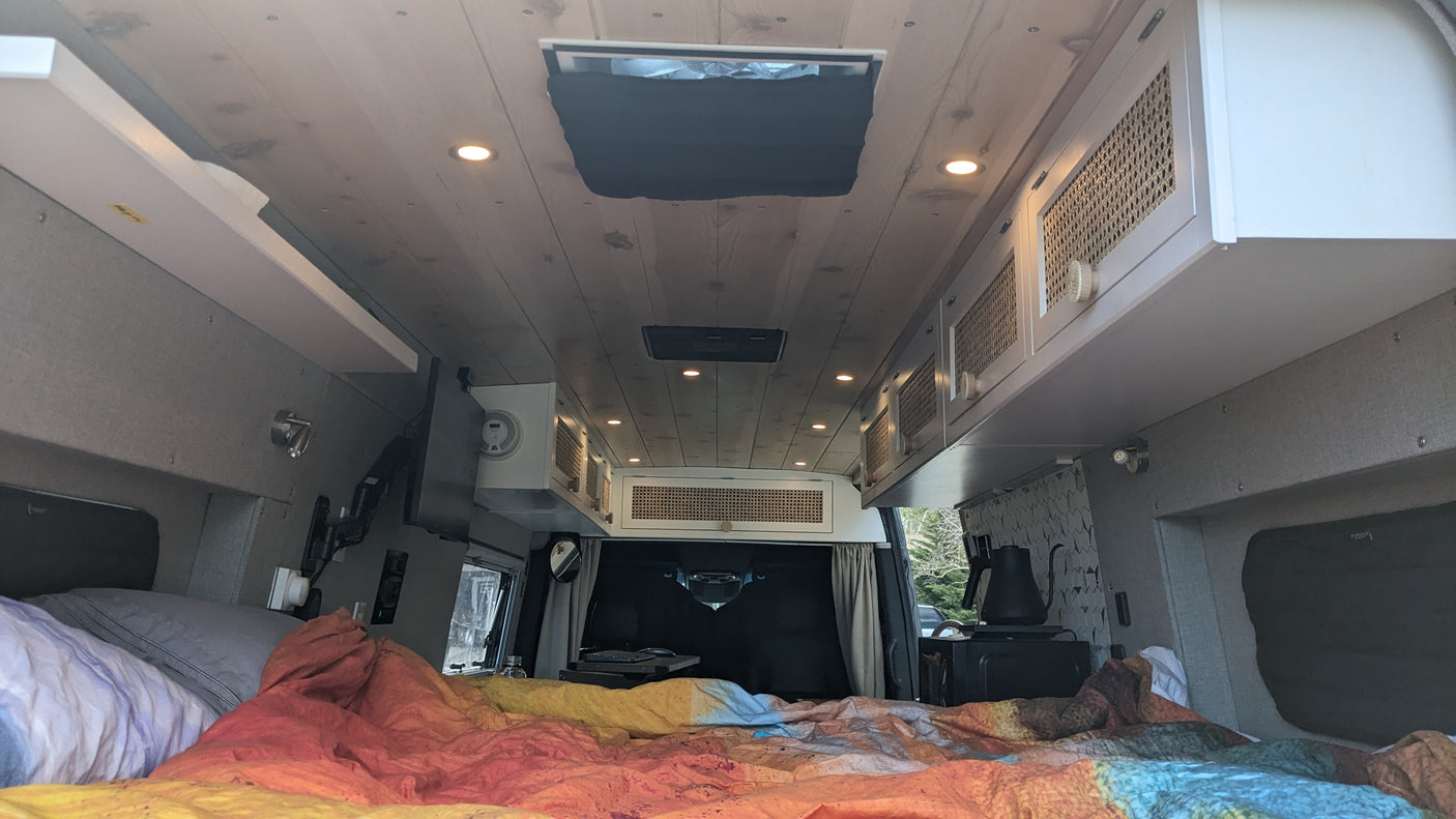 Experience comfort in this rv rental! Features a custom wood ceiling, cozy bed, and practical overhead storage for your road trip.
