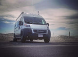 White Ram ProMaster camper van, an excellent rv rental choice, parked by sandy dunes under a cloudy sky.