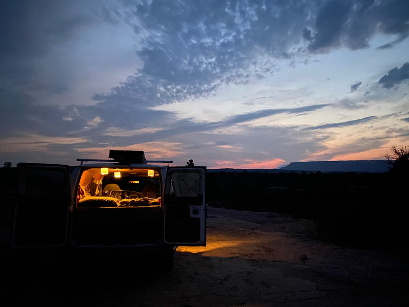 RV rental parked at dusk with illuminated interior and open doors, offering a view of a flat-topped mountain under a colorful sky. — photo 14