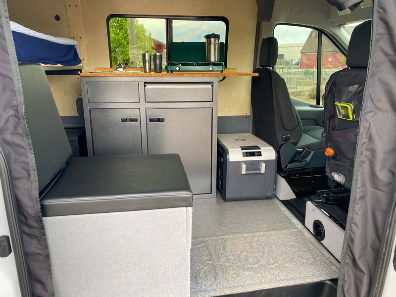  offering a scenic adventure amid snow-capped peaks.|Inside a well-equipped RV rental van: kitchen with stove & sink — photo 5