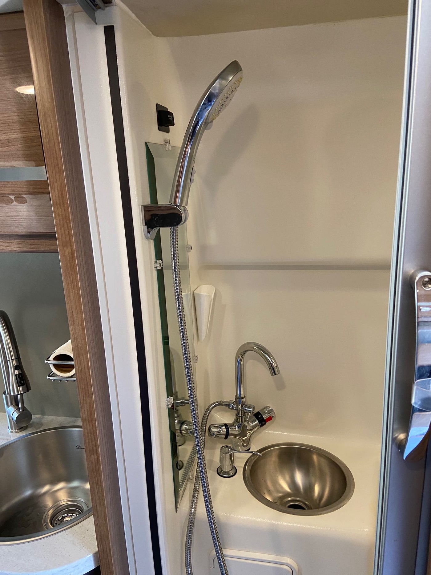  and modern amenities inside.|Compact RV rental interior featuring a kitchen area with sink & wood cabinets — photo 15