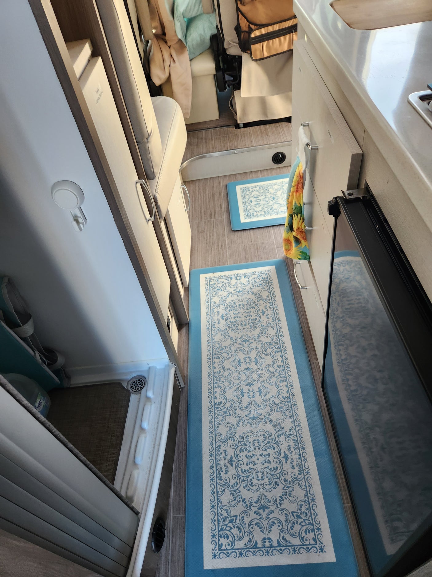 Bright, organized RV rental interior with a kitchen area, comfortable seating, and under-seat storage solutions.