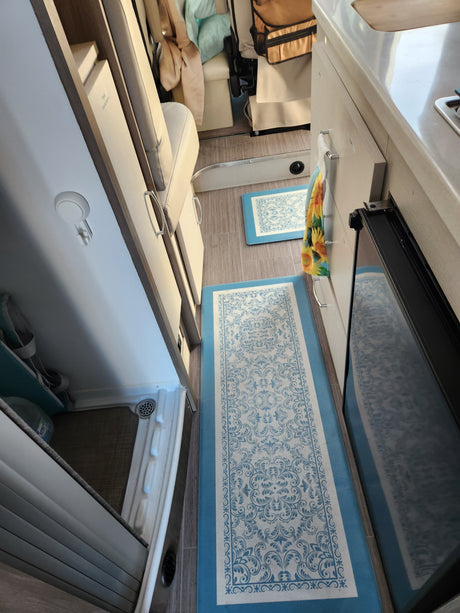 Bright, organized RV rental interior with a kitchen area, comfortable seating, and under-seat storage solutions.