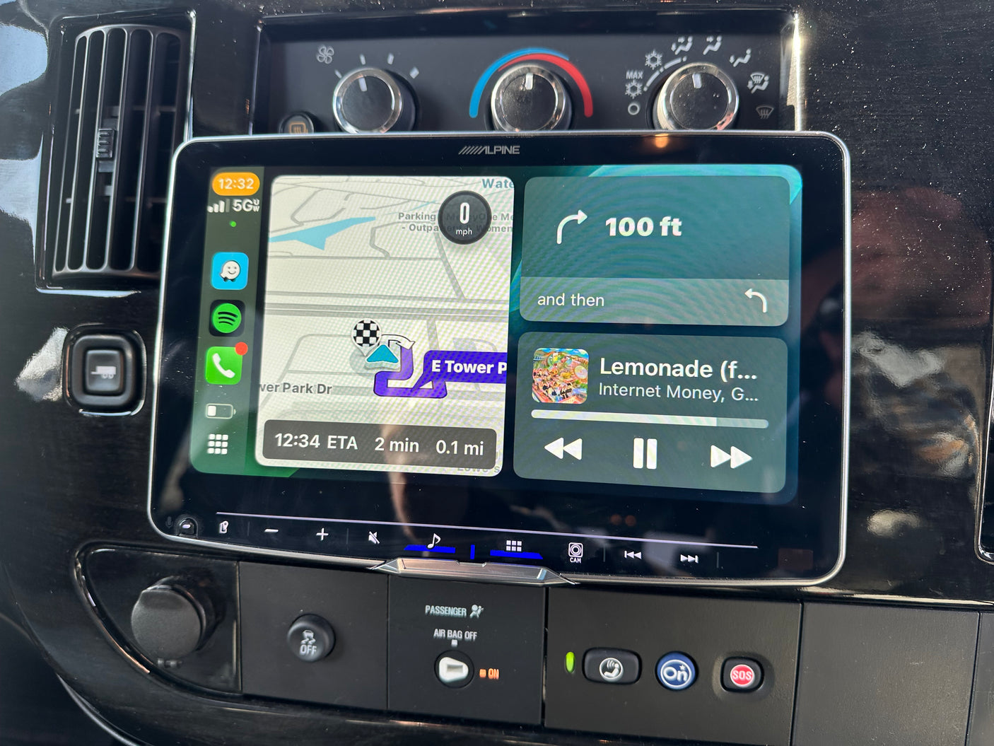Dashboard of an RV rental with an Alpine infotainment system showing split-screen navigation and music.
