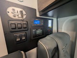 This RV rental's control panel features monitors for battery, solar, Aqua-Hot, tank levels, light switches, and Euroloft bed controls.