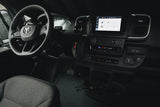 Driver's cockpit of a modern Ram van, great for an RV rental. Features infotainment screen, steering wheel & multiple charging ports.