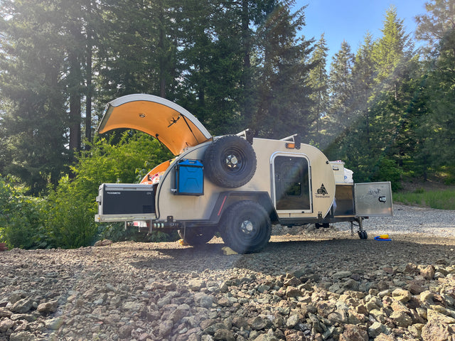 This teardrop camper, a perfect rv rental, features a Dometic fridge & Wavian container for forest camping.