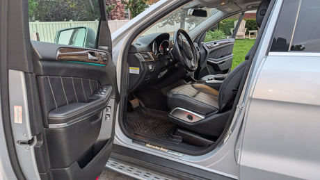 Detailed Mercedes-Benz SUV interior: black leather, wood trim, ambient light. Perfect for travel, even with your RV rental plans.