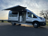 Explore this custom silver Ford Transit camper van RV rental with extended awning & visible interior.