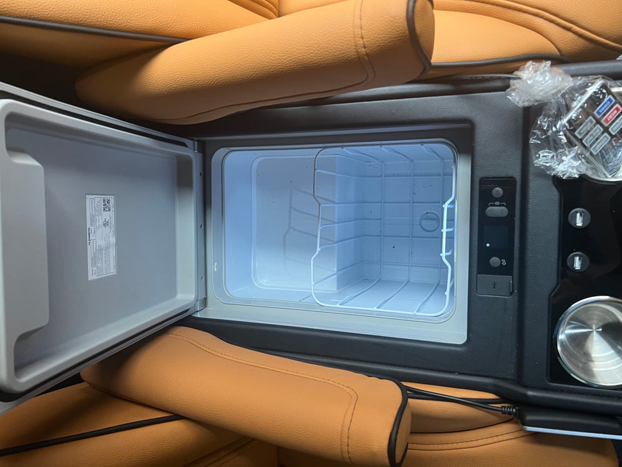 RV rental luxury: Dometic mini-fridge in a tan leather interior, offering cool convenience on the go. Perfect for road trips!