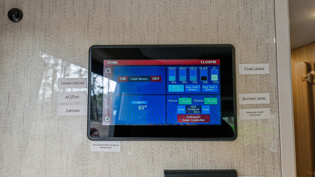 An RV rental's digital control panel shows tank & battery levels, climate (69°), lights, generator, and more for convenience.