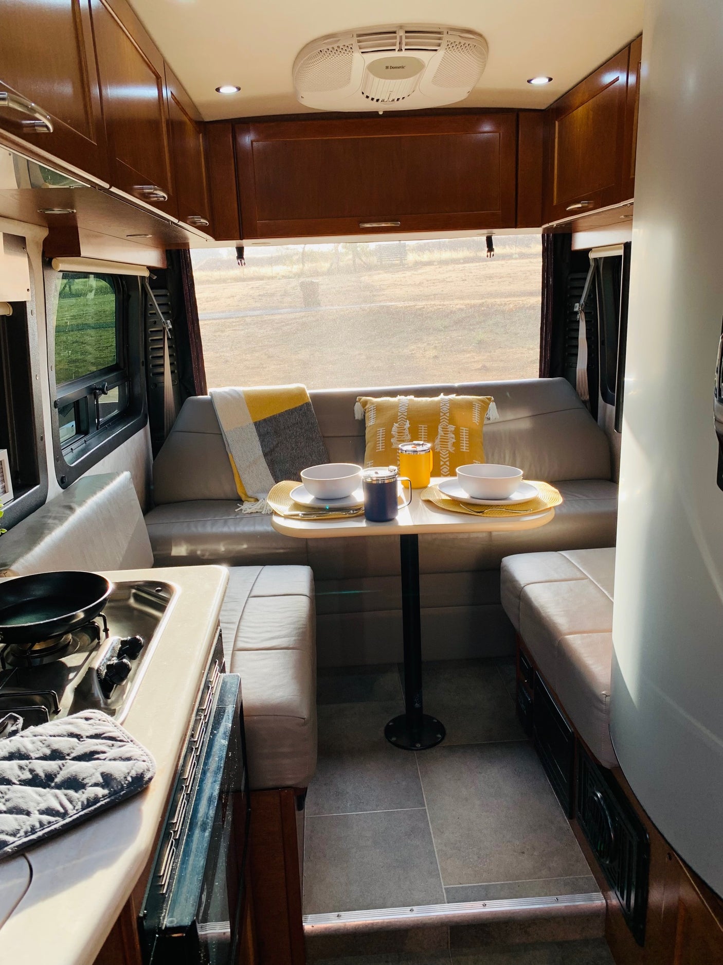 Cozy RV rental interior with dining area, kitchen, and comfy seating, ready for adventure.