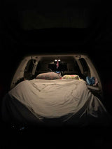 Cozy car bed in an SUV at night, ideal for road trip adventures. A practical RV rental alternative for campers.