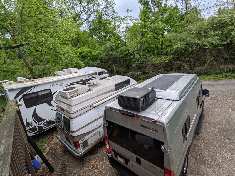 Overhead view of three parked RVs (Winnebago, Coachmen, Tioga) nestled among trees, perfect for rv rental adventures. — photo 18