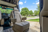 Luxury RV rental: Relax in a plush captain's chair with an open-door view of a serene suburban street.