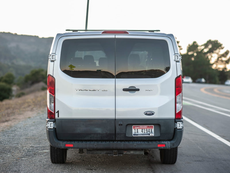  and kitchen for comfortable road trips.|A silver Ford Transit RV rental van with roof racks — photo 3