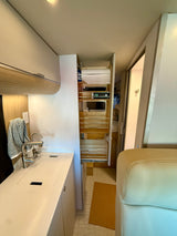 Explore this RV rental's clever compact kitchen with a sink, faucet, and an organized pull-out pantry.