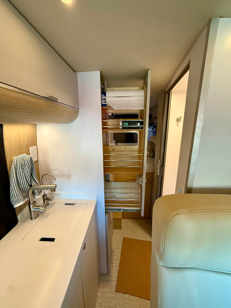 Explore this RV rental's clever compact kitchen with a sink, faucet, and an organized pull-out pantry.