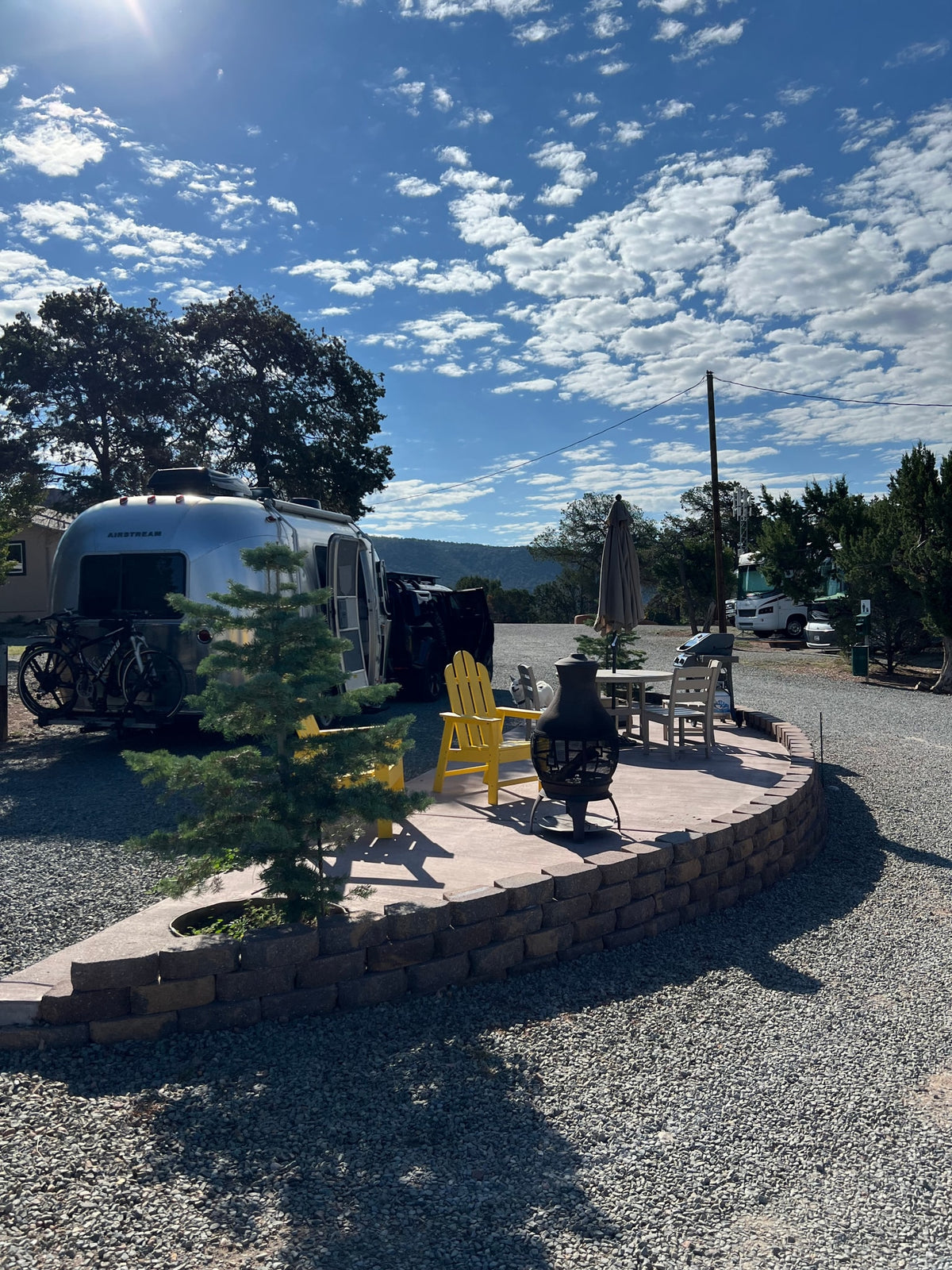 Your RV rental adventure begins here! A gleaming Airstream and bikes with a comfortable patio, chairs, and fire pit. — photo 7